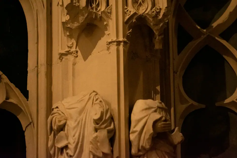 Carved figures on the Chartres choir screen lit warm against the surrounding stone