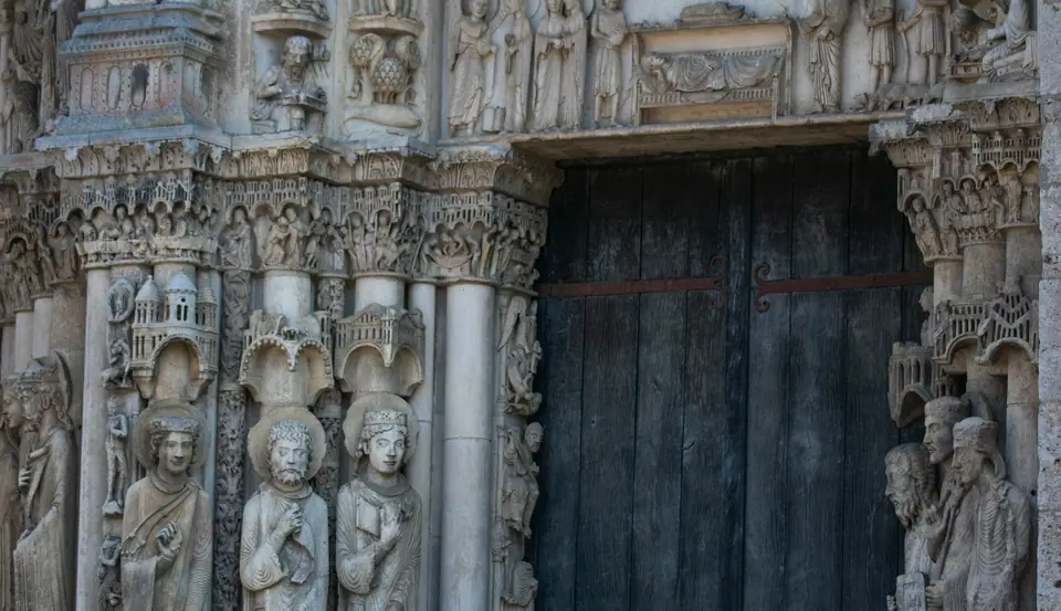 Column statues carved into the jambs beside the cathedral's weathered timber door
