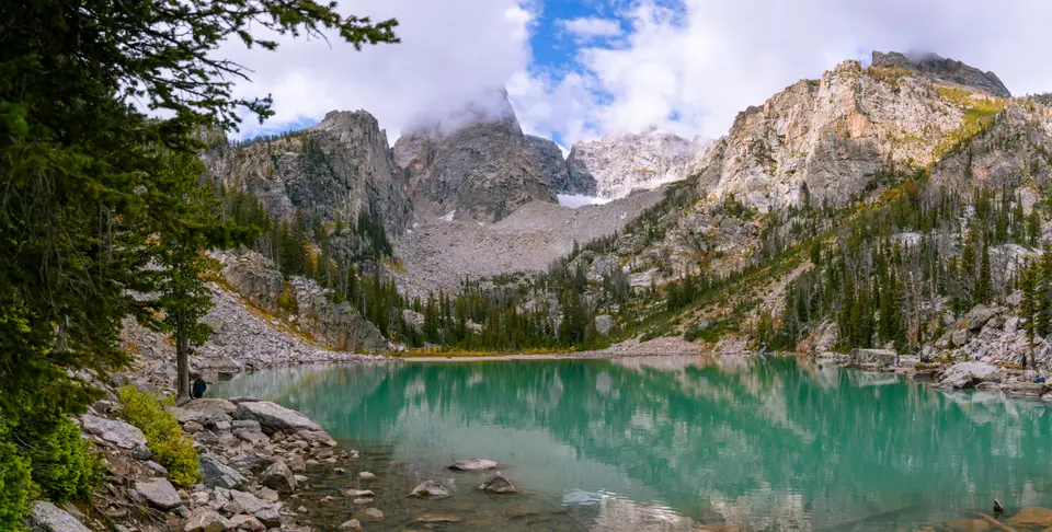 Landscapes — Turquoise glacial water of Delta Lake below the granite peaks of the Grand Teton, cloud on the summit